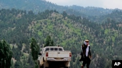 FILE - A Taliban militant is seen walking in Pakistan's tribal region of North Waziristan. Aug. 12, 2013. American author Paul Overby was hoping to reach to the region when he went missing in May of 2014.